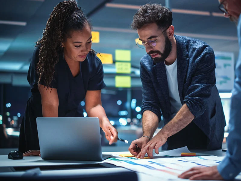 Ein diverses Team von Top-Managern, das in einem modernen Büro miteinander spricht - Über uns